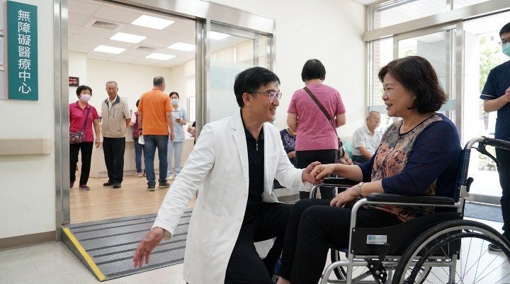 吳紹琥醫師與坐輪椅患者討論醫療平權空間設計。 設有低平台診療床與寬敞動線的醫療平權友善診間。 醫護人員接受專業移位訓練實踐診所醫療平權精神。 具備斜坡道與感應門的醫療平權無障礙診所外觀。